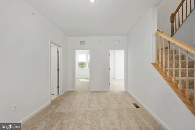 a view of staircase with wooden floor and white walls