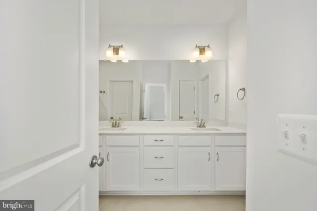 a spacious bathroom with a double vanity sink and a mirror
