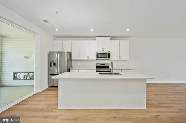 a kitchen with cabinets stainless steel appliances and a counter space