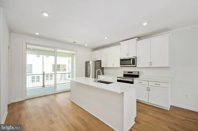 a kitchen with stainless steel appliances a refrigerator sink and microwave