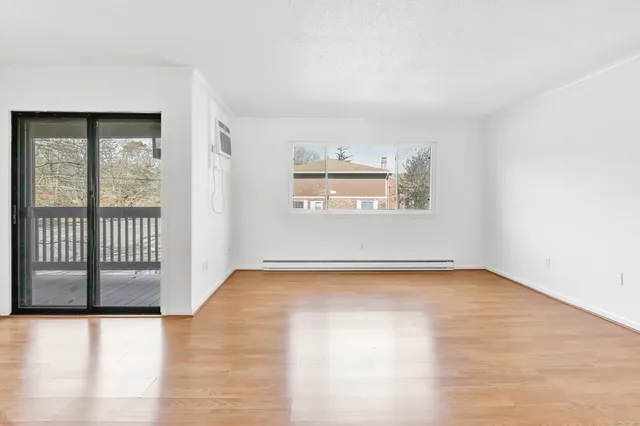 a view of a livingroom with wooden floor and a window