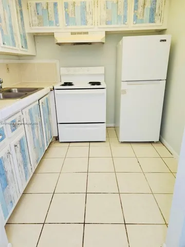 a kitchen with a stove and a white refrigerator