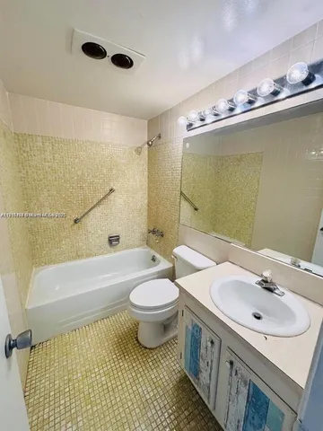 a bathroom with a sink toilet a mirror and bathtub