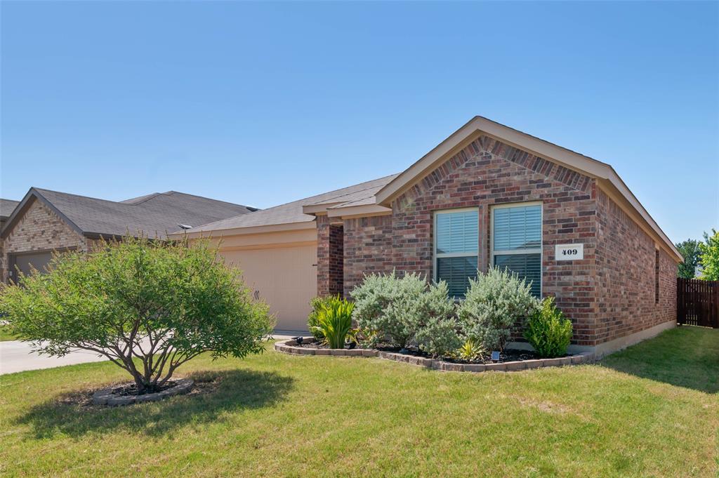 409 Wilson Way Denton, TX 76207 - Photo 6 of 33 Brick facade residence featuring a two-car garage, pitched roof, and front landscaping