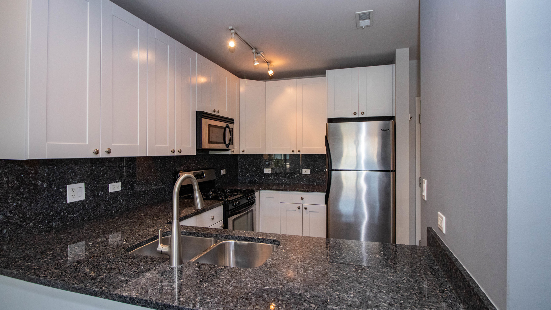 657 West Fulton Street, Unit 412 Chicago, IL 60661 - Photo 11 of 25 a kitchen with stainless steel appliances granite countertop a refrigerator a sink and a stove