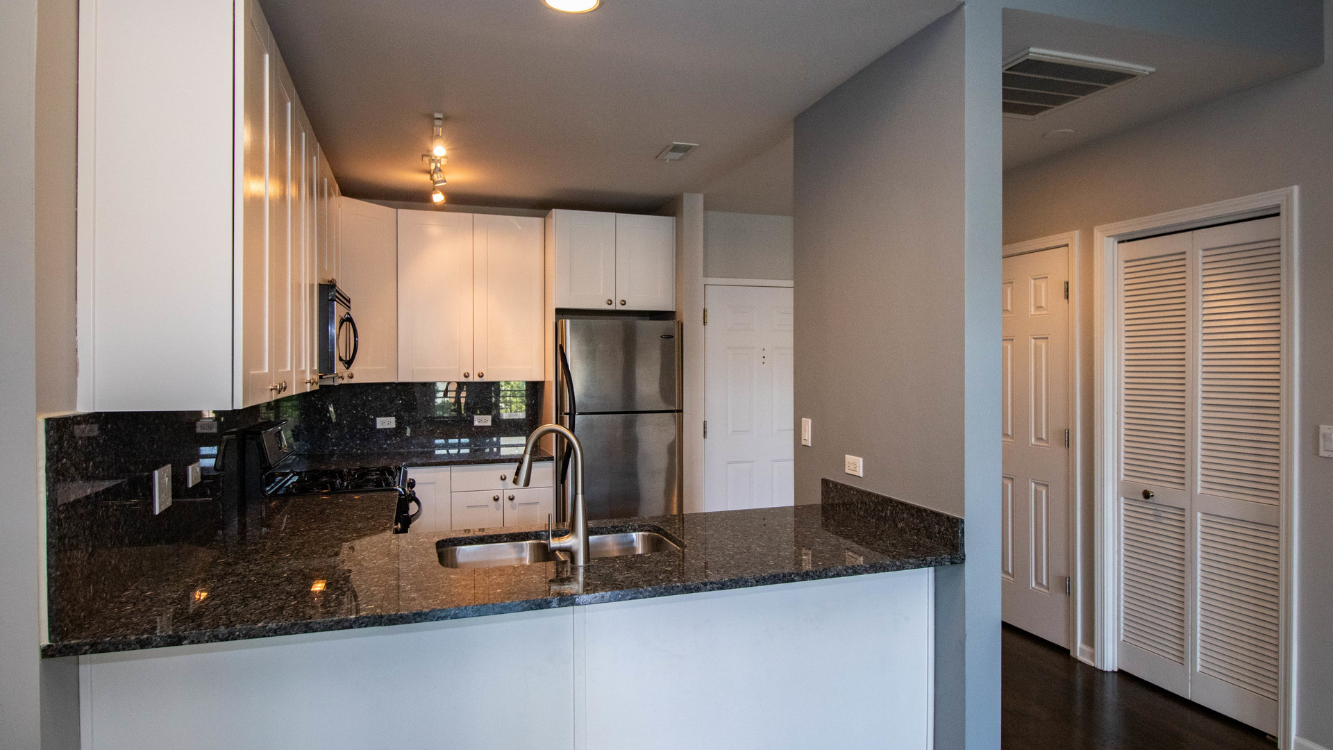 657 West Fulton Street, Unit 412 Chicago, IL 60661 - Photo 12 of 25 a kitchen with kitchen island a counter top space a sink and cabinets