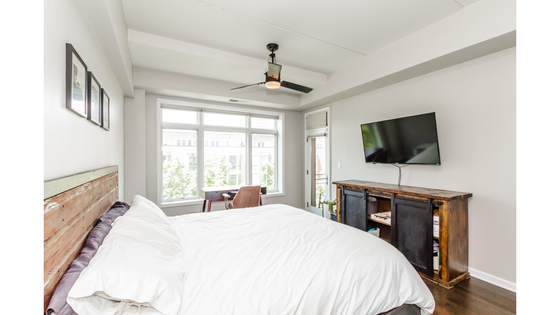 657 West Fulton Street, Unit 412 Chicago, IL 60661 - Photo 14 of 25 a bedroom with a bed and a flat tv screen on dresser