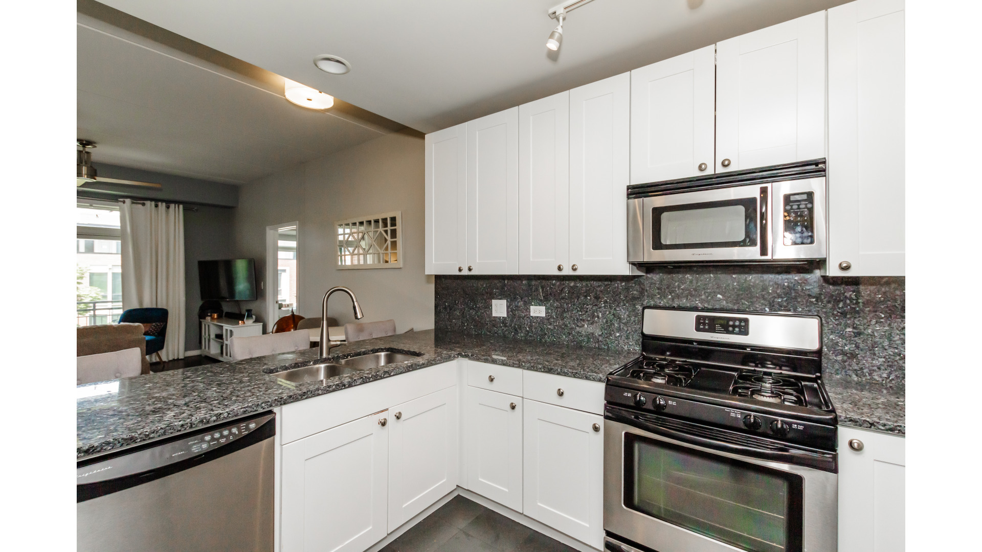 657 West Fulton Street, Unit 412 Chicago, IL 60661 - Photo 9 of 25 a kitchen with granite countertop a sink stove and microwave