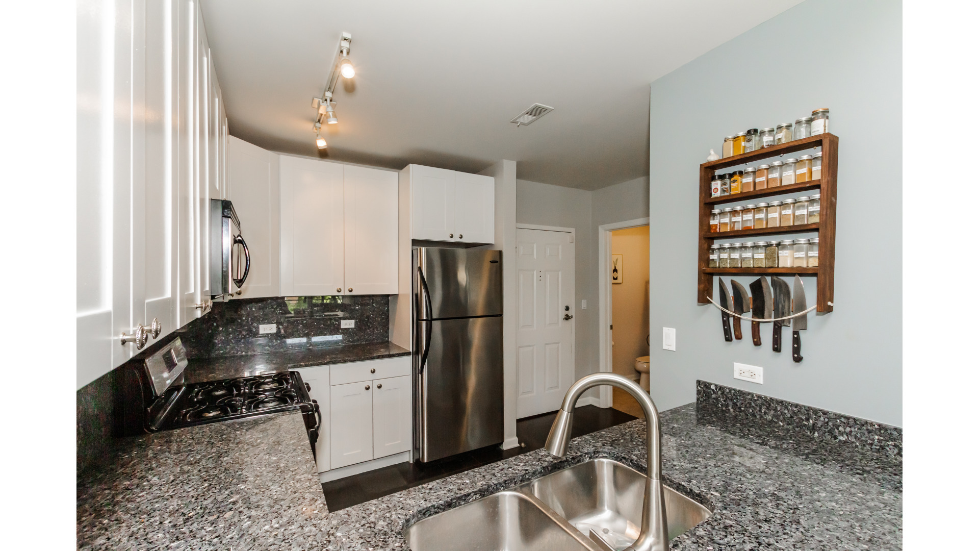 657 West Fulton Street, Unit 412 Chicago, IL 60661 - Photo 10 of 25 a kitchen with granite countertop a stove and a refrigerator
