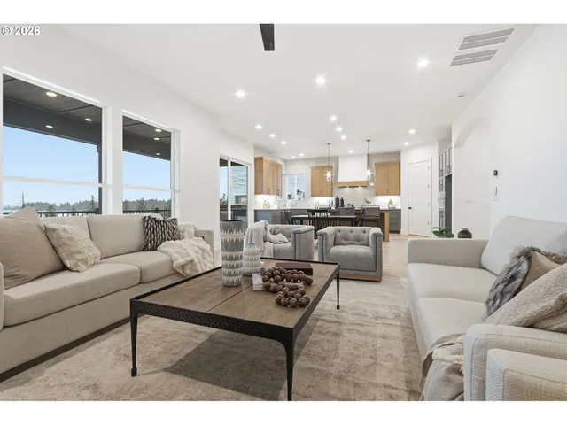 a living room with furniture and a dining table with kitchen view