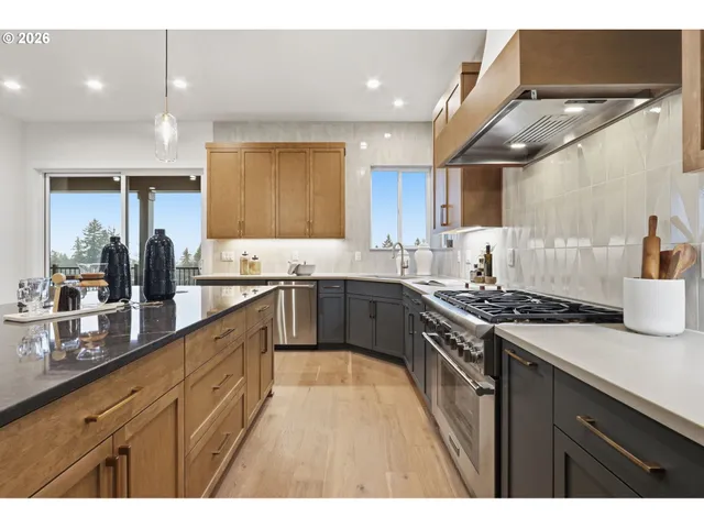 a large kitchen with stainless steel appliances granite countertop a stove a sink dishwasher and a oven with cabinets