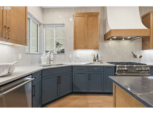a kitchen with stainless steel appliances granite countertop a sink stove and cabinets