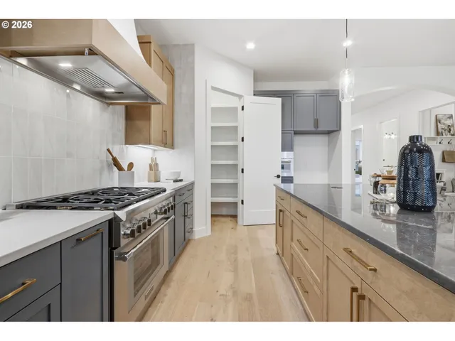 a kitchen with stainless steel appliances granite countertop a stove a sink and a refrigerator