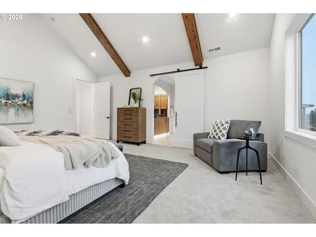 a spacious bedroom with a bed a couch and dresser