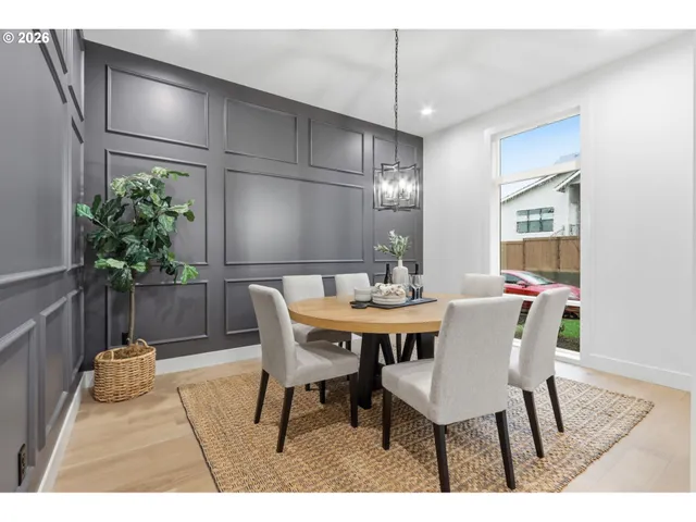 a dining room with furniture potted plants and wooden floor