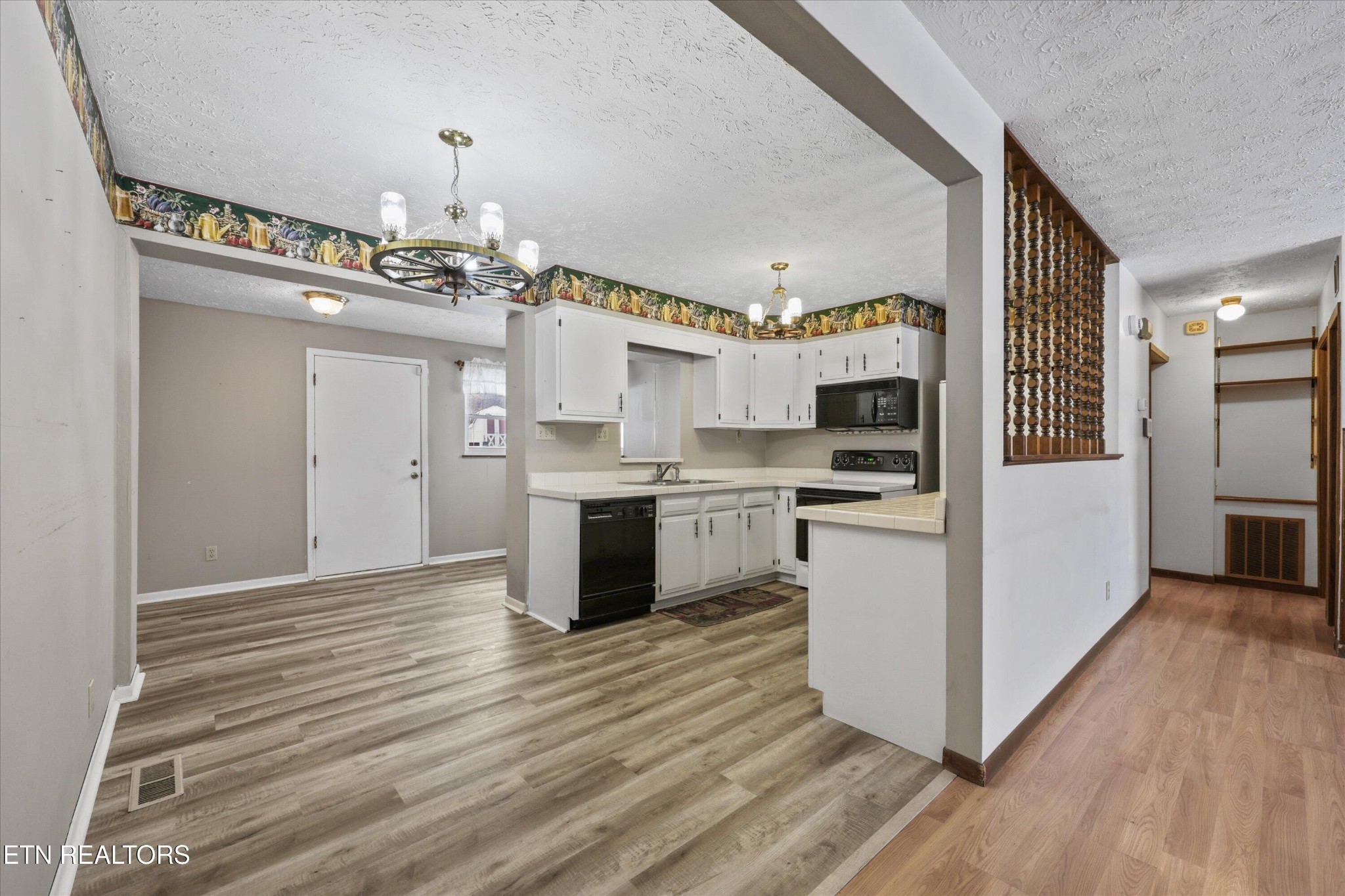 359 East Wolf Valley Road Heiskell, TN 37754 - Photo 7 of 40 a kitchen with granite countertop a refrigerator oven a sink dishwasher and white cabinets with wooden floor
