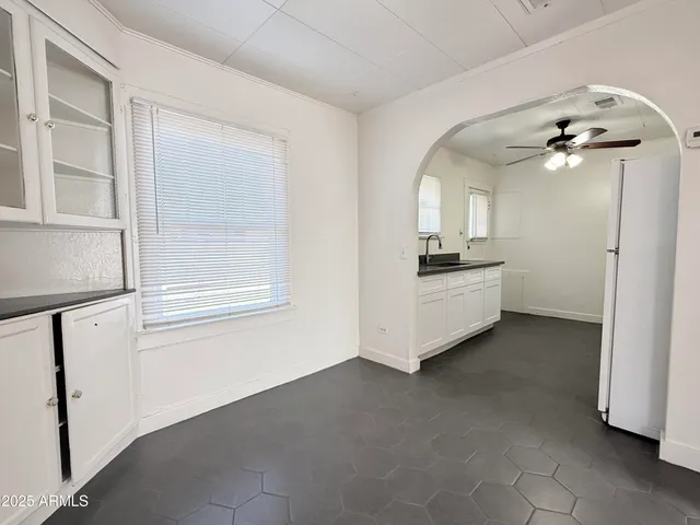 a view of a kitchen with a sink and cabinet wooden floor windows