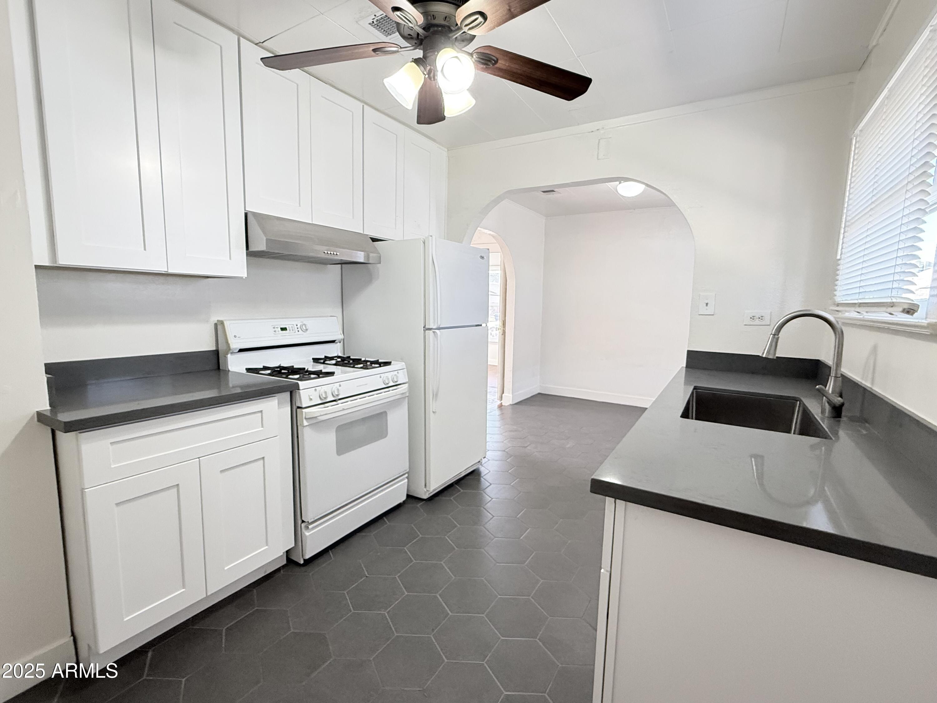 3809 North 9th Place Phoenix, AZ 85014 - Photo 16 of 28 a kitchen with granite countertop white cabinets and white appliances