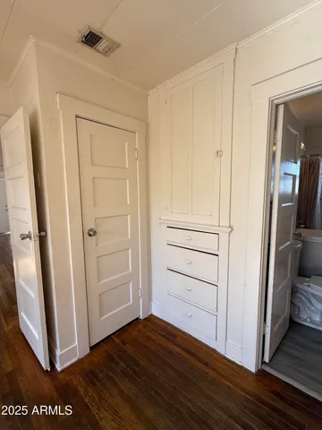a view of a closet area with hardwood floor