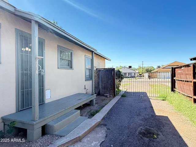 a view of a backyard with wooden floor and fence