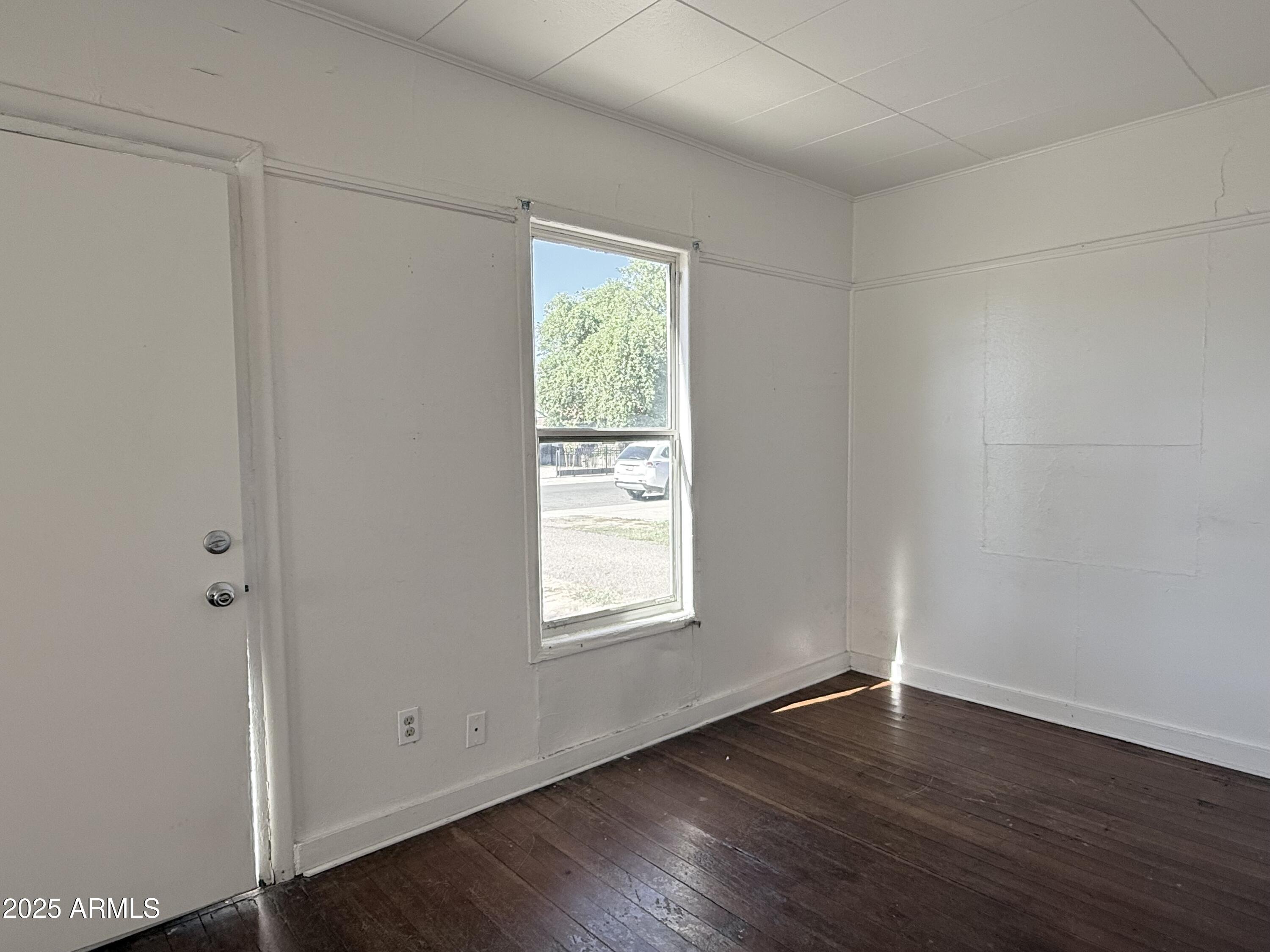 3809 North 9th Place Phoenix, AZ 85014 - Photo 6 of 28 an empty room with wooden floor and window