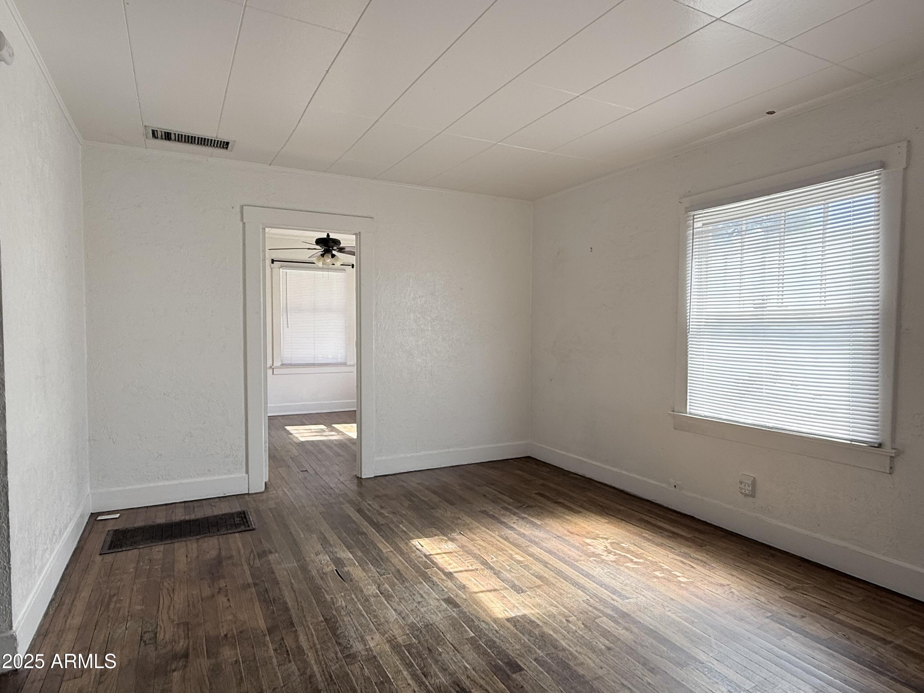 3809 North 9th Place Phoenix, AZ 85014 - Photo 7 of 28 an empty room with wooden floor and windows