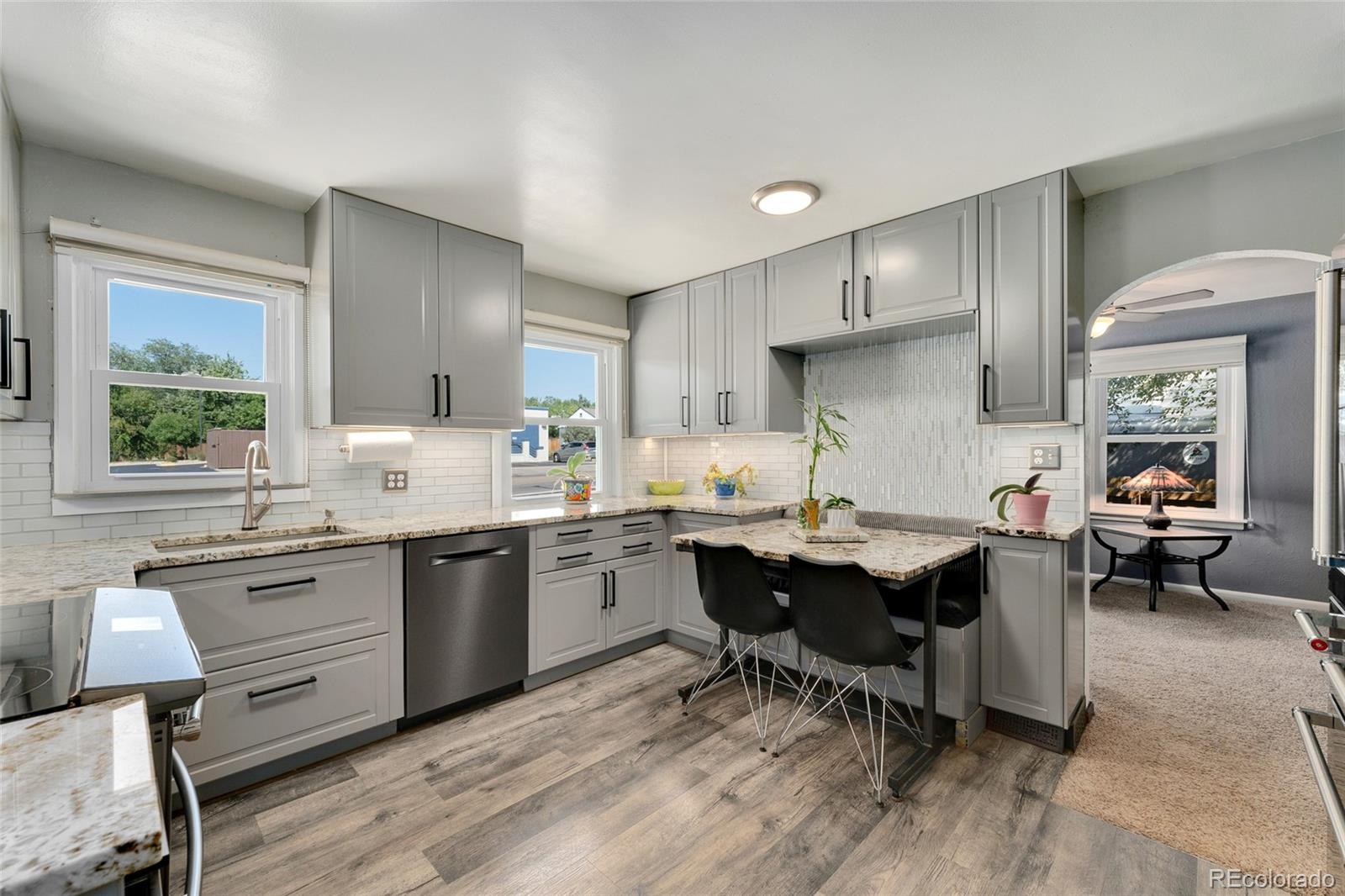 1530 Simms Street Lakewood, CO 80215 - Photo 1 of 38 a kitchen with sink cabinets and dining table chair