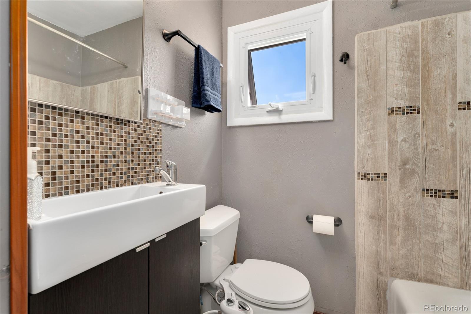 1530 Simms Street Lakewood, CO 80215 - Photo 13 of 38 a bathroom with a sink a toilet and shower