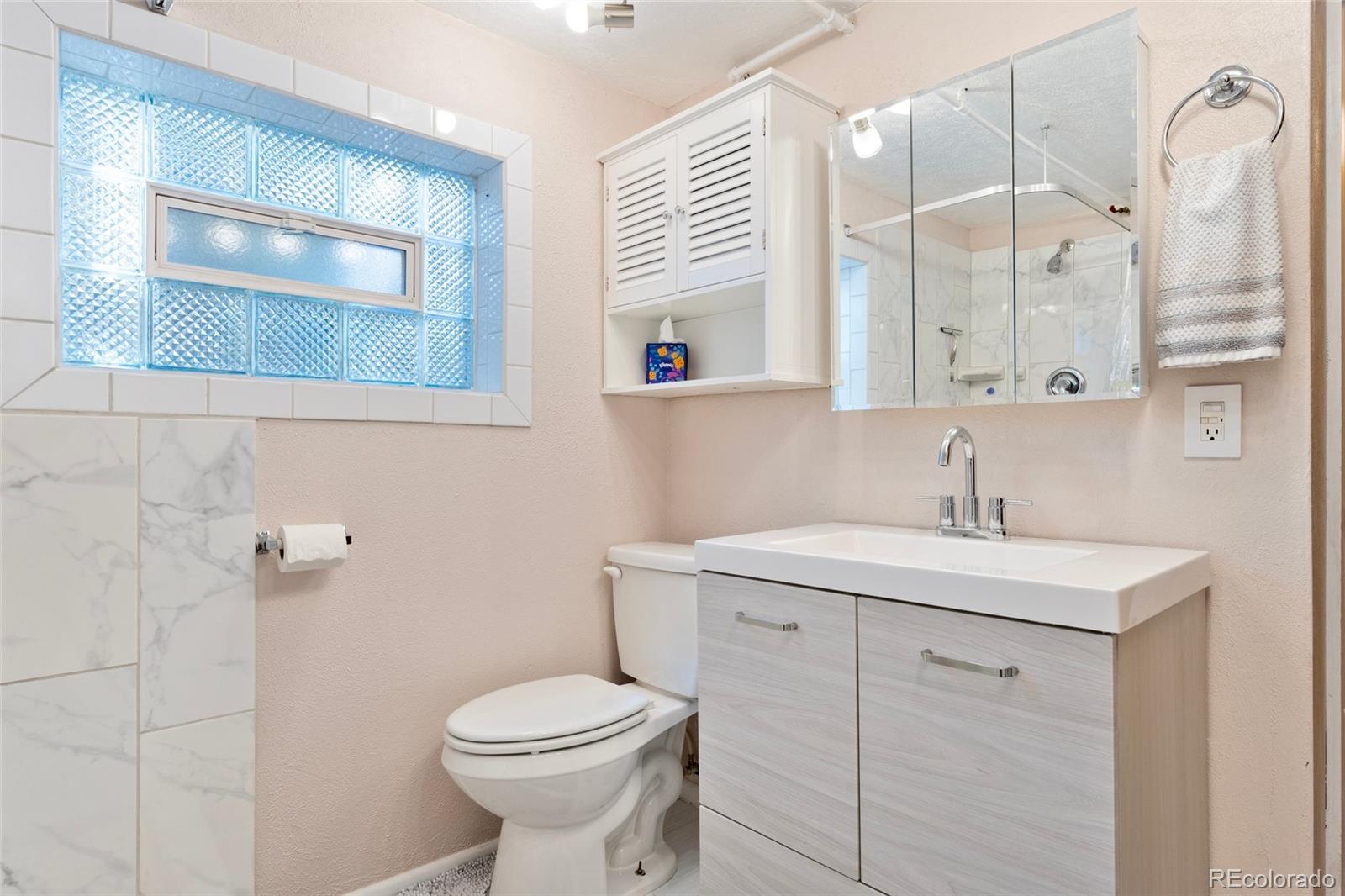 1530 Simms Street Lakewood, CO 80215 - Photo 19 of 38 a bathroom with a sink a toilet and a mirror