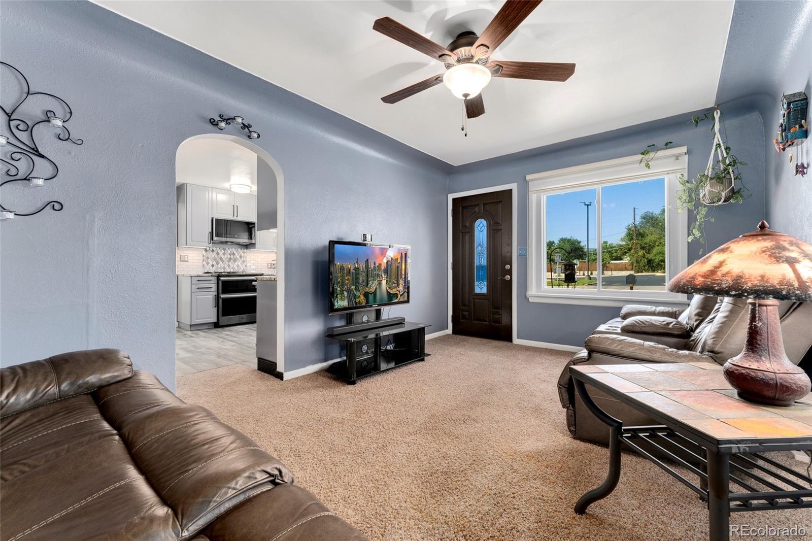 1530 Simms Street Lakewood, CO 80215 - Photo 6 of 38 a living room with furniture a fireplace and a flat screen tv