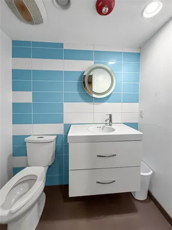 a bathroom with a sink mirror vanity and toilet