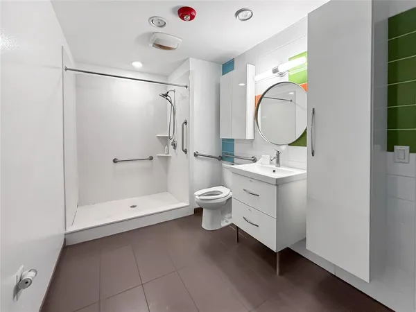 a bathroom with a sink a toilet and shower