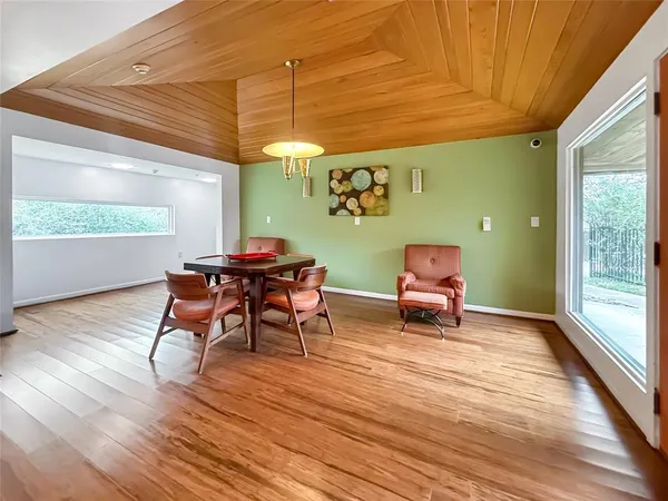 a dining room with furniture and wooden floor