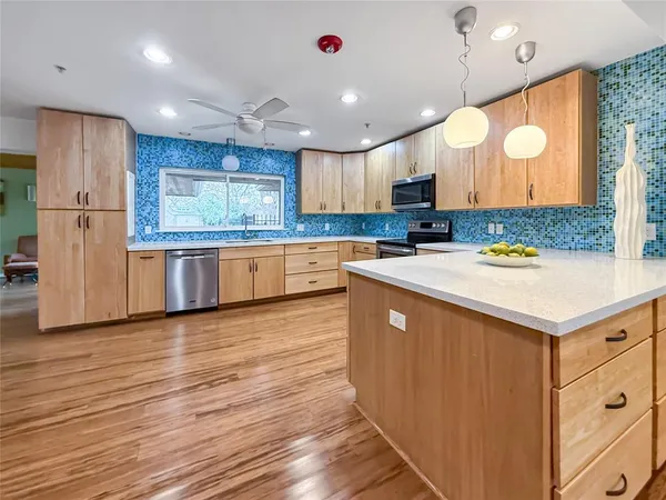 a kitchen with stainless steel appliances granite countertop a sink a stove and a refrigerator