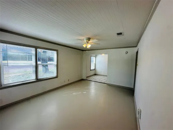 a view of a big room with windows and chandelier fan