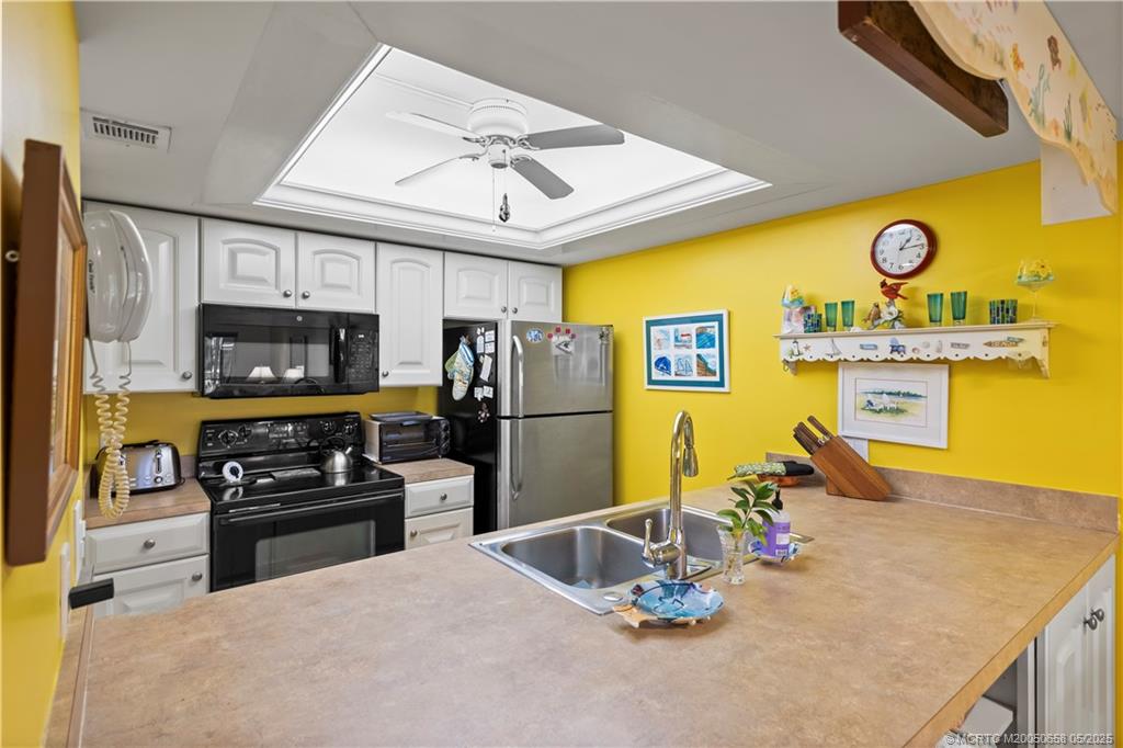 5571 Northeast Gulfstream Way Stuart, FL 34996 - Photo 14 of 40 a kitchen with stainless steel appliances granite countertop a sink a stove and refrigerator