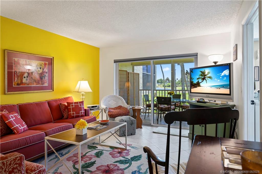 5571 Northeast Gulfstream Way Stuart, FL 34996 - Photo 17 of 40 a living room with furniture and a flat screen tv