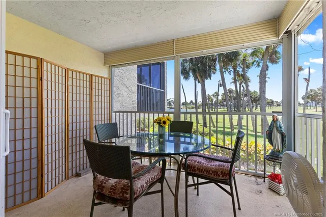 a dining room with furniture a chandelier and glass door