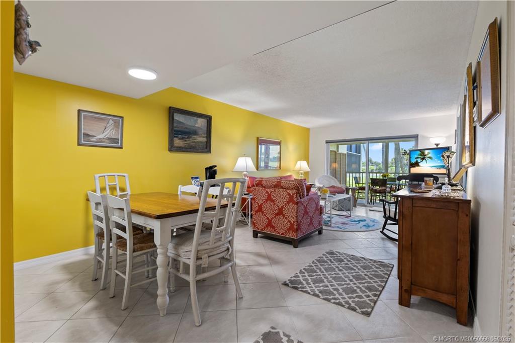 5571 Northeast Gulfstream Way Stuart, FL 34996 - Photo 21 of 40 a living room with furniture a flat screen tv and a table