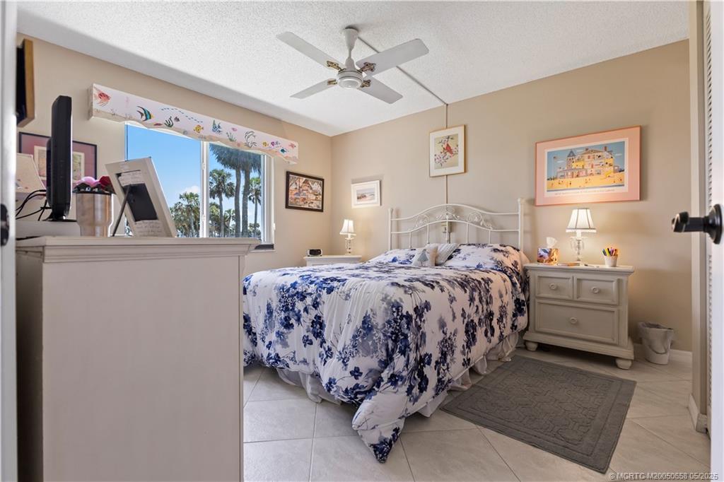 5571 Northeast Gulfstream Way Stuart, FL 34996 - Photo 24 of 40 a bed room with a bed mirror and a window