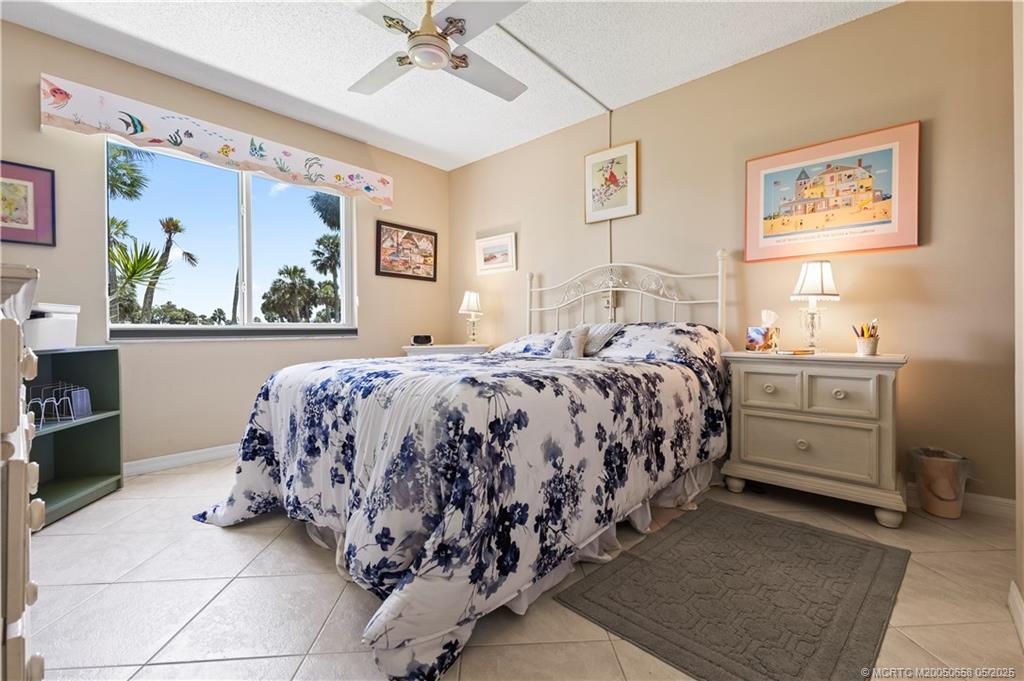5571 Northeast Gulfstream Way Stuart, FL 34996 - Photo 25 of 40 a bedroom with a bed and a painting on the wall