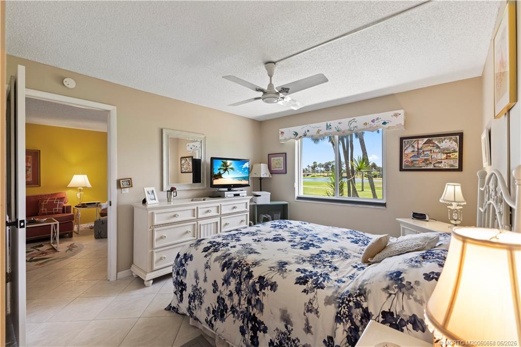 5571 Northeast Gulfstream Way Stuart, FL 34996 - Photo 26 of 40 a bedroom with a bed and a flat screen tv