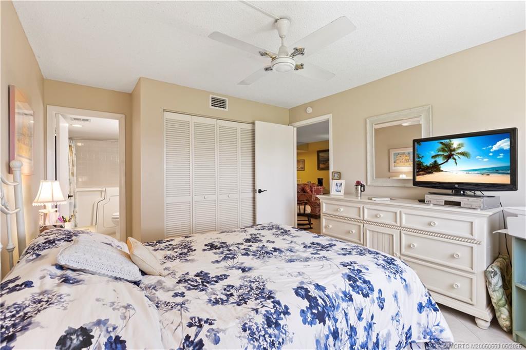 5571 Northeast Gulfstream Way Stuart, FL 34996 - Photo 27 of 40 a bedroom with a bed and a flat screen tv in it