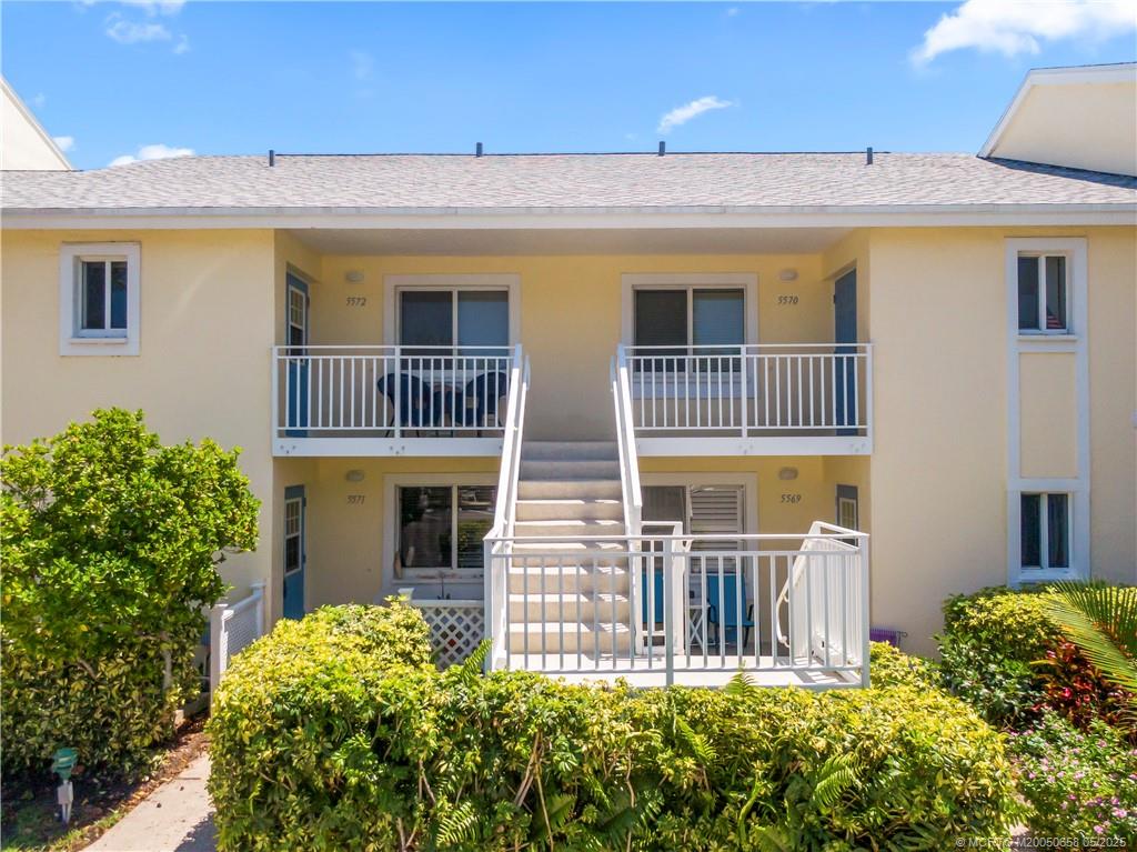 5571 Northeast Gulfstream Way Stuart, FL 34996 - Photo 33 of 40 a front view of a house with a garden