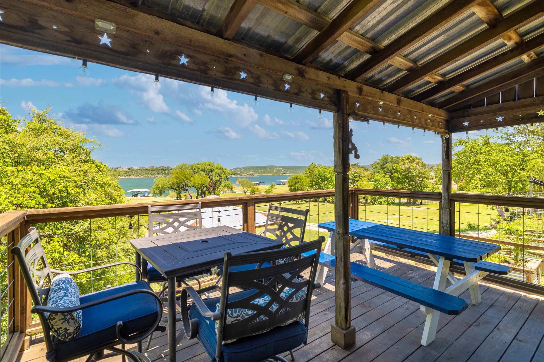 16800 Forest Way Austin, TX 78734 - Photo 9 of 15 Enjoy water views and lush greenery from this spacious covered patio with a wooden deck and rustic charm.