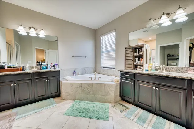 a spacious bathroom with a tub sink and a mirror