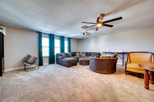 a living room with furniture and a ceiling fan