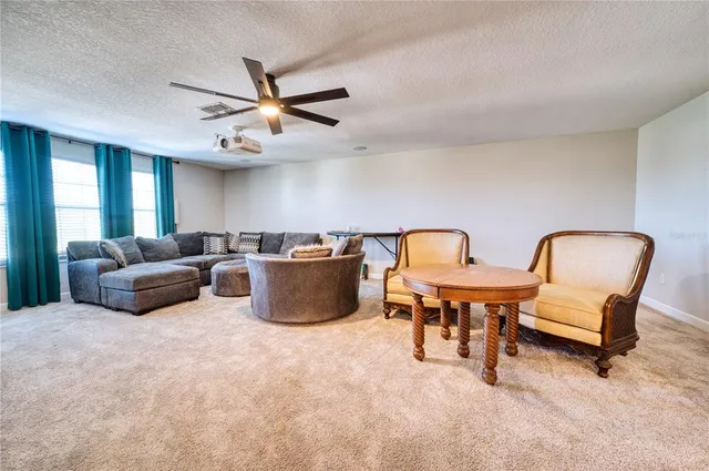 a living room with furniture kitchen view and a chandelier