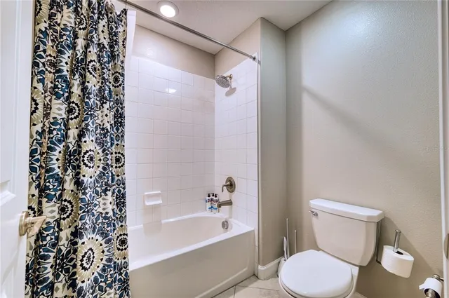 a white toilet sitting next to a bath tub