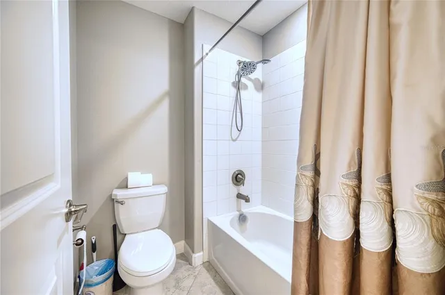 a white toilet sitting next to a bath tub